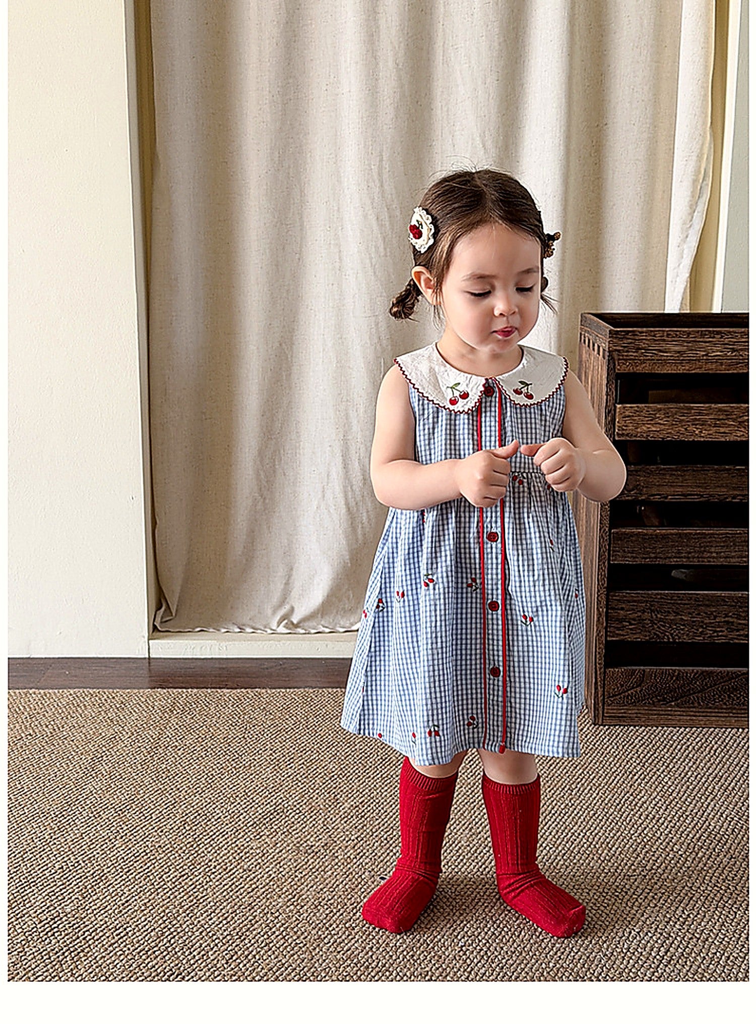 A girl in the Bluebell Pinafore, a vintage blue-striped summer pinafore.