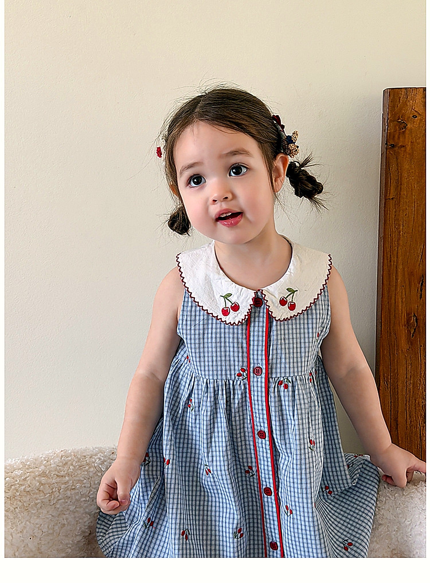 A toddler in the Bluebell Pinafore, soft afternoon light.