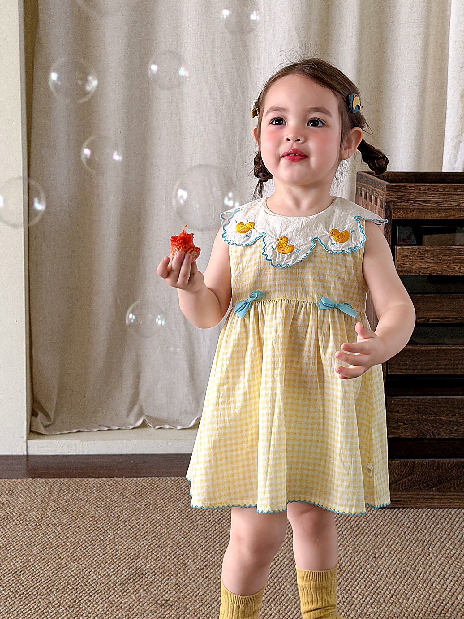 Front of the Buttercup Pinafore — embroidered daisies and a duckling on a white collar.