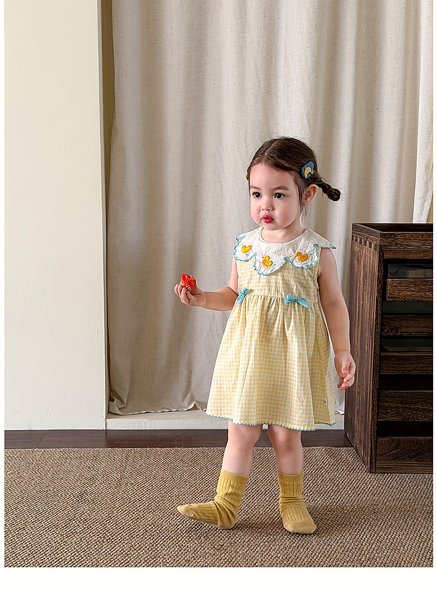 A young girl in the yellow Buttercup Pinafore on a warm summer day.