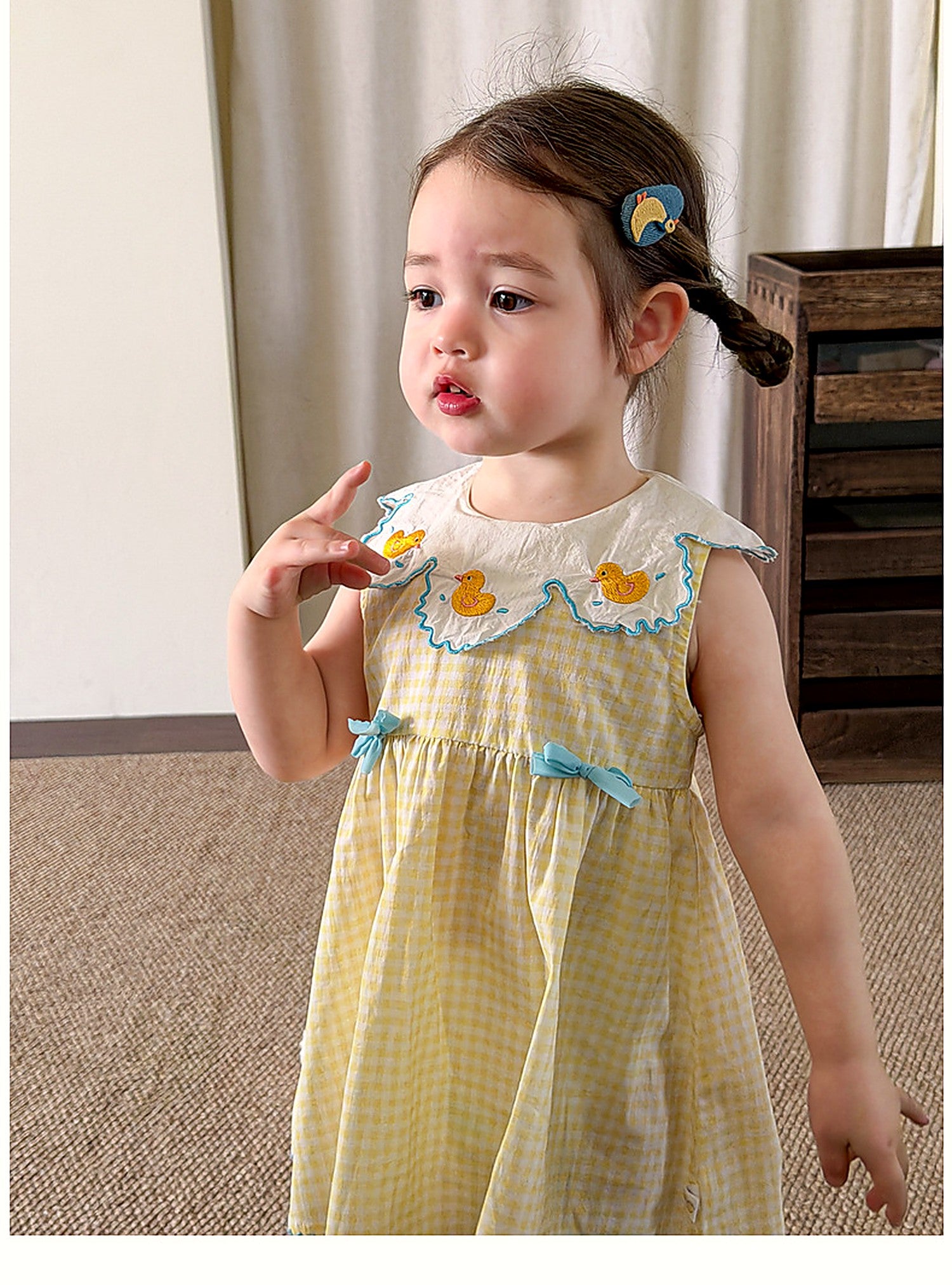 A toddler in the Buttercup Pinafore, soft afternoon light.