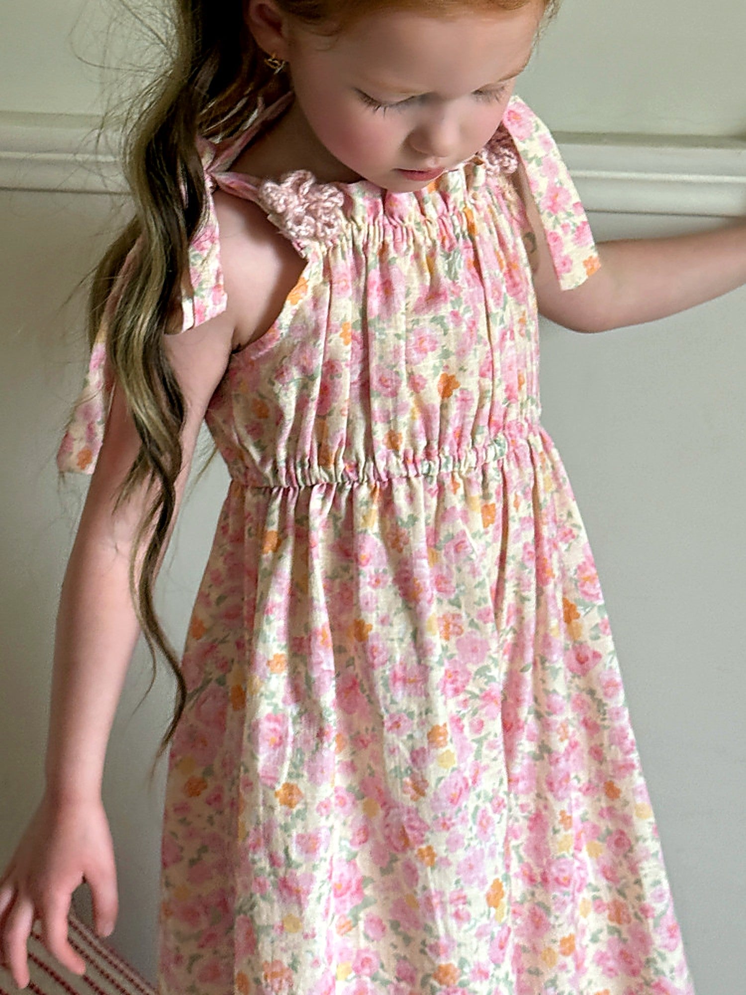 A girl in the pink floral Clover Romper on a warm summer day.