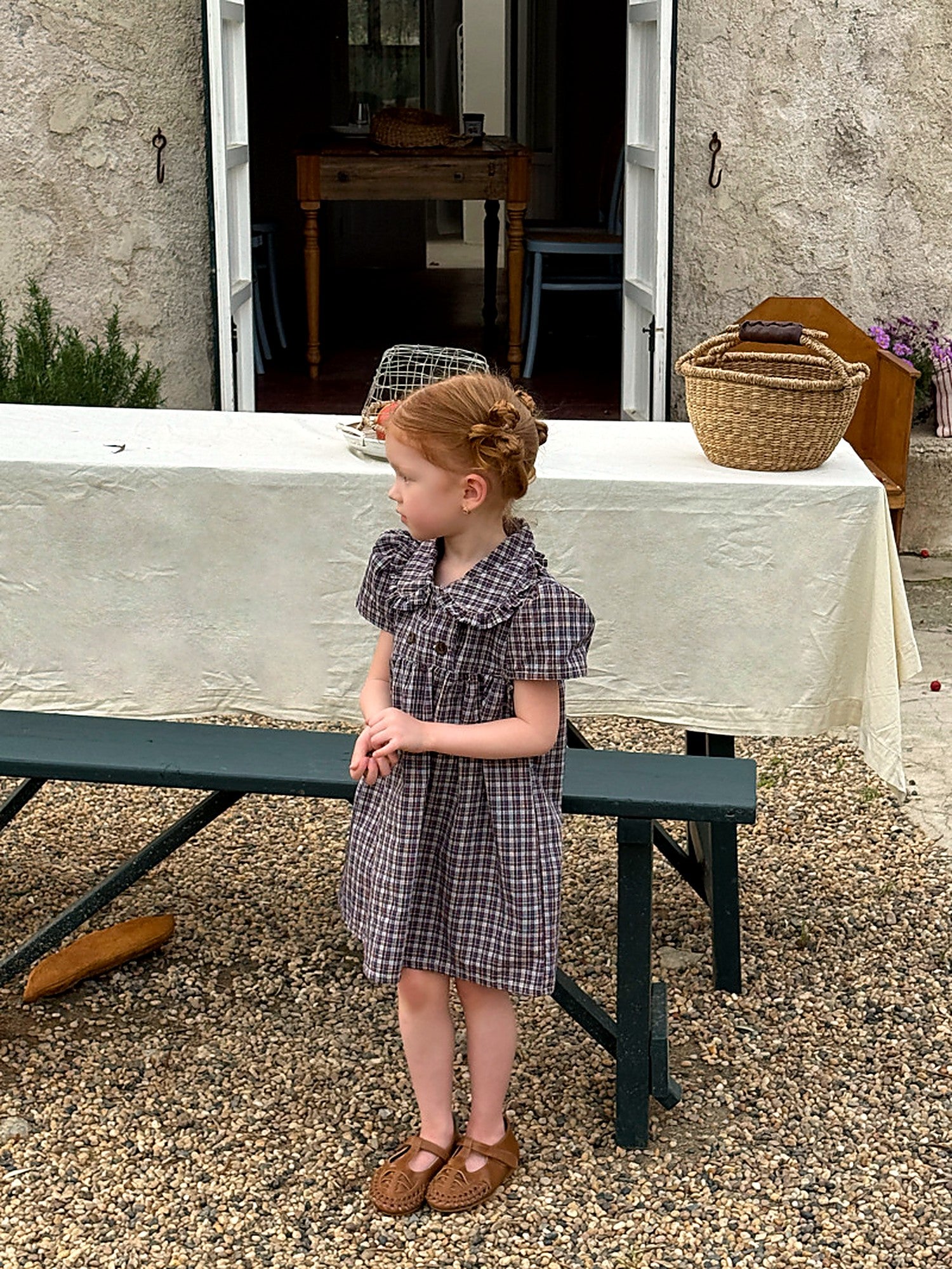 A girl in the Cornflower Dress by a wooden bench and lavender, soft light.