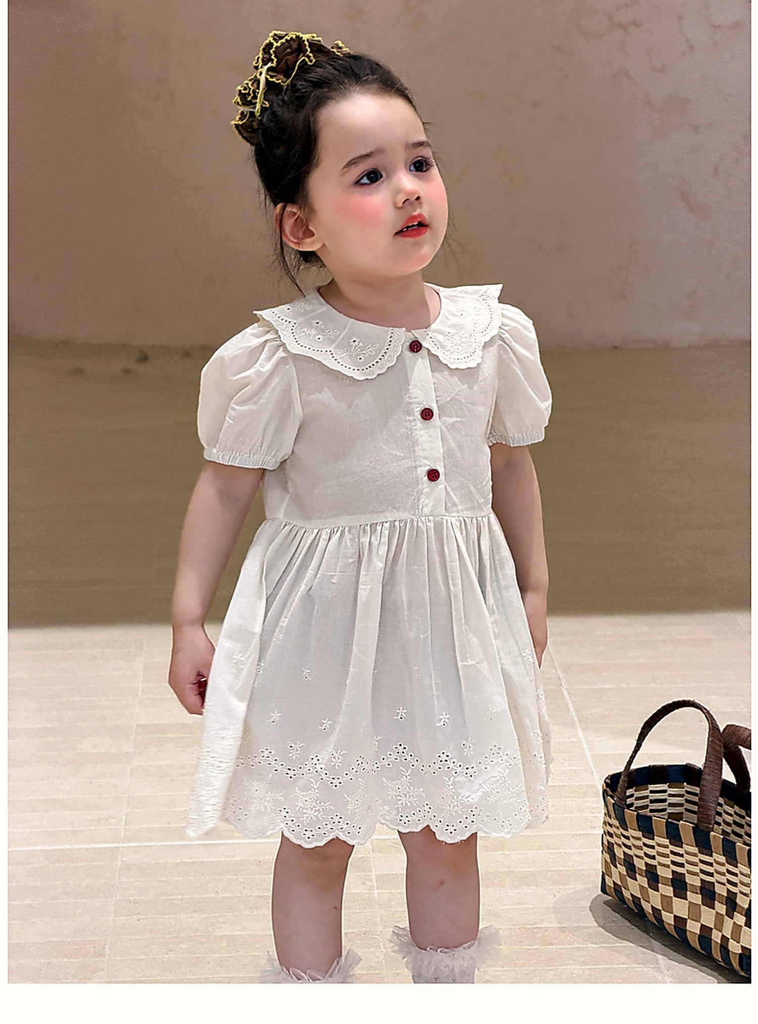 A young girl in the ivory Daisy Dress on a warm summer day.