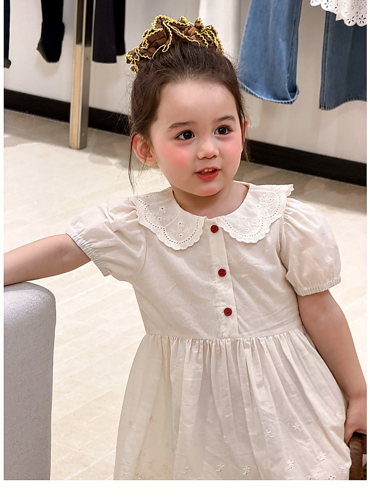 A girl in the Daisy Dress, a vintage white summer dress.