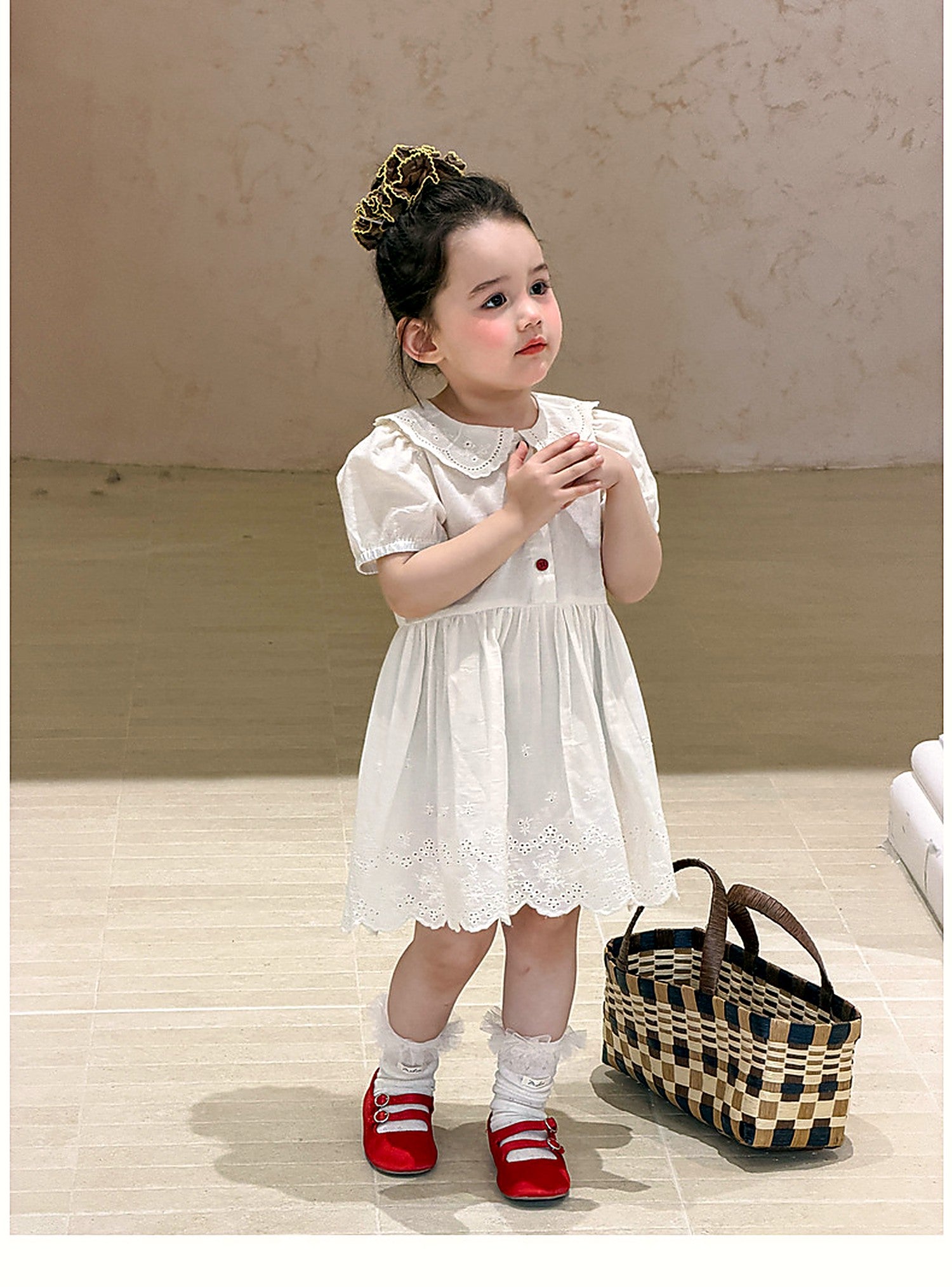 A toddler in the Daisy Dress, soft afternoon light.