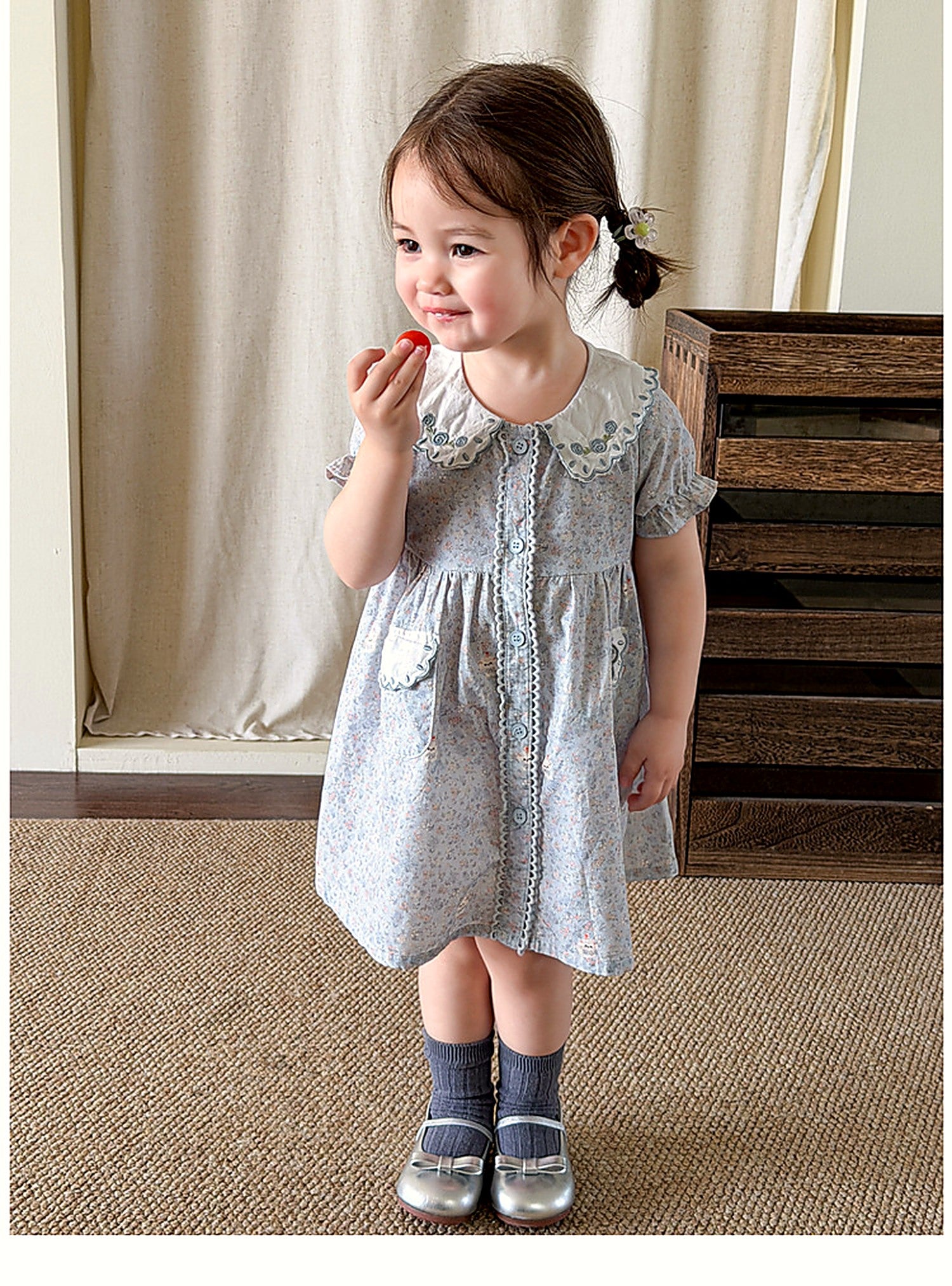 A toddler in the Forget-me-not Dress, soft afternoon light.