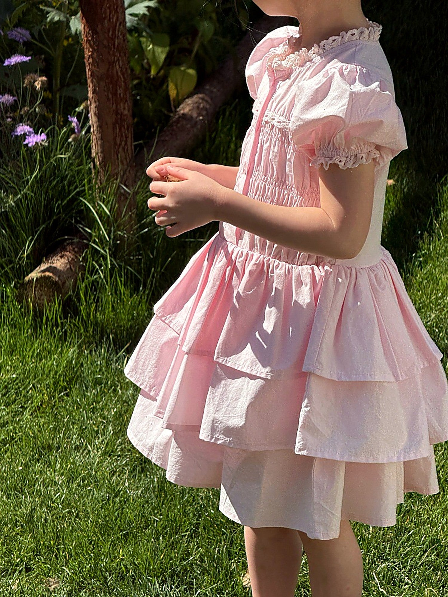 Front of the Foxglove Dress — smocked bodice, puff sleeves and a tiered skirt in pink cotton.