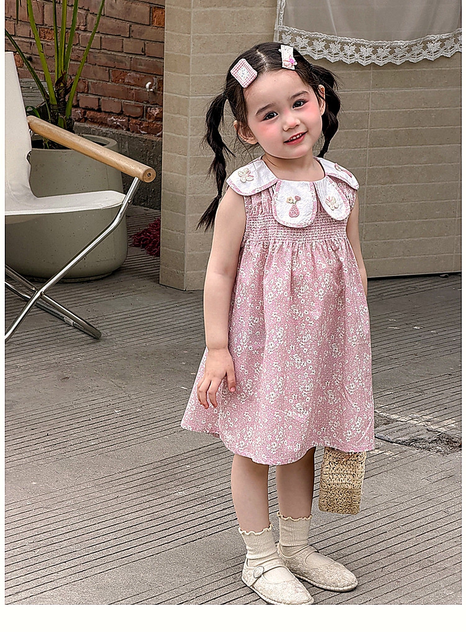A young girl in the dusty-pink Hazel Dress on a warm summer day.