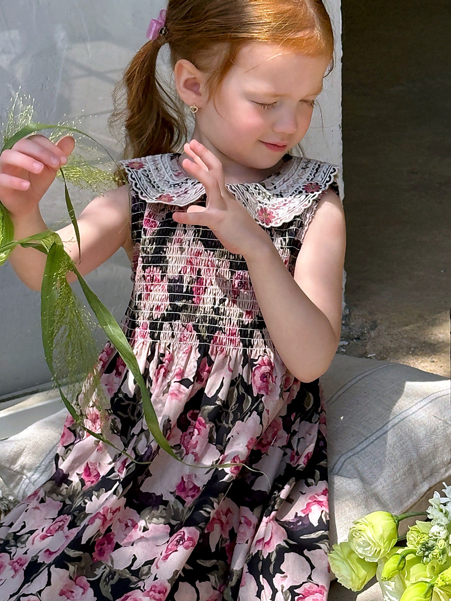 A girl in the floral Hollyhock Dress on a warm summer day.