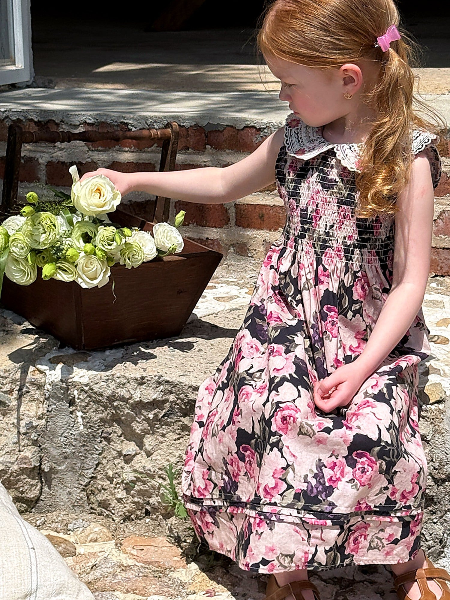 A girl in the Hollyhock Dress by hydrangeas, soft afternoon light.