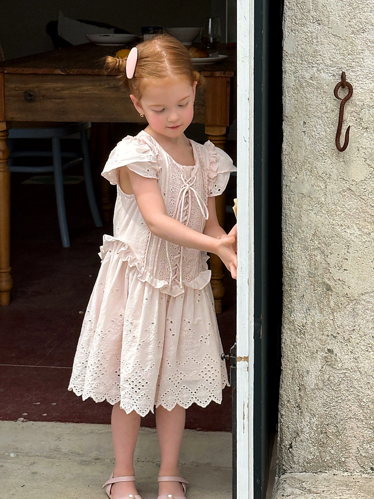 A girl reading in the Mallow Dress, a French-vintage summer dress in pink.