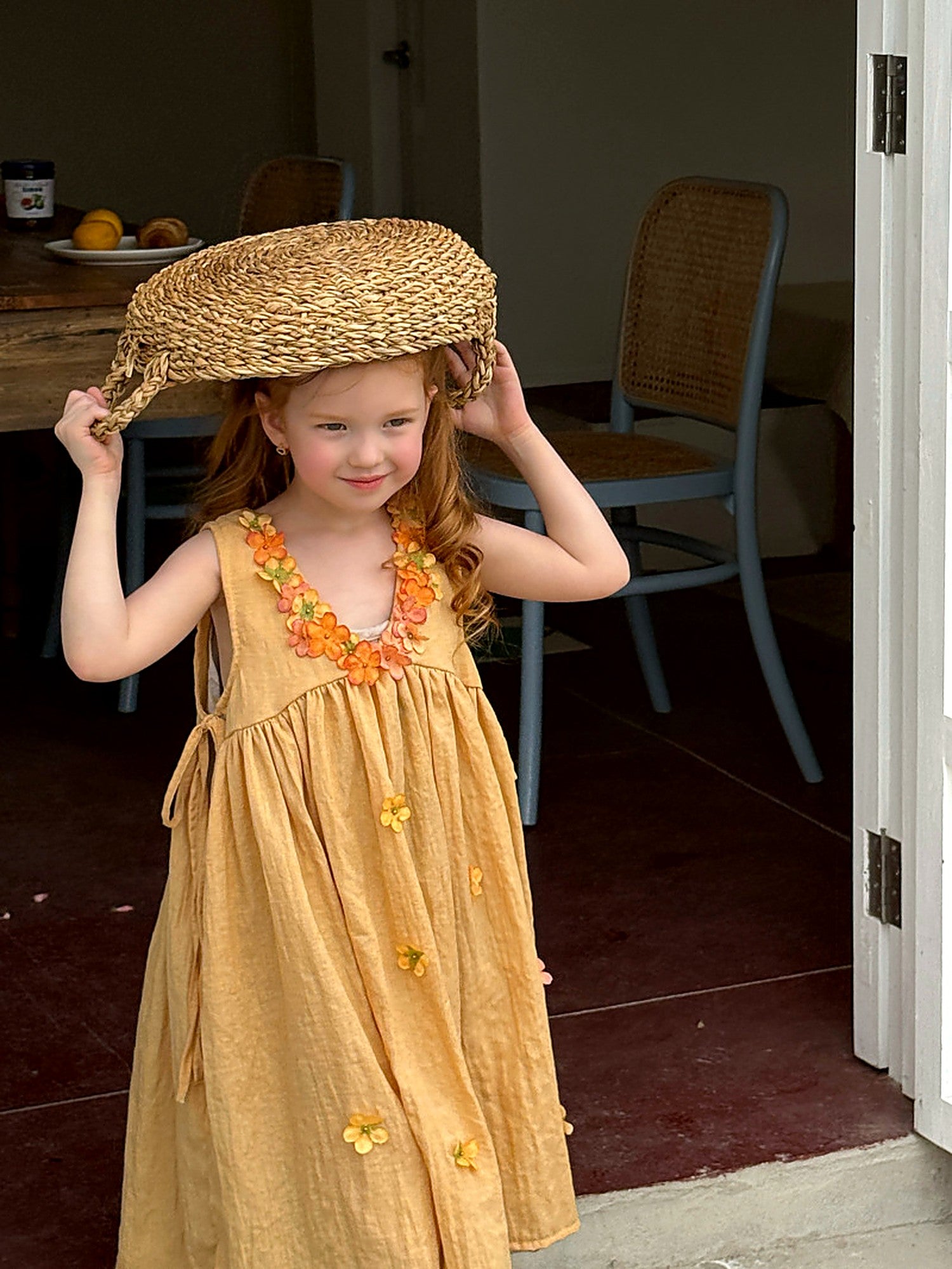 The gathered, tiered skirt of the Marigold Dress in washed mustard cotton.