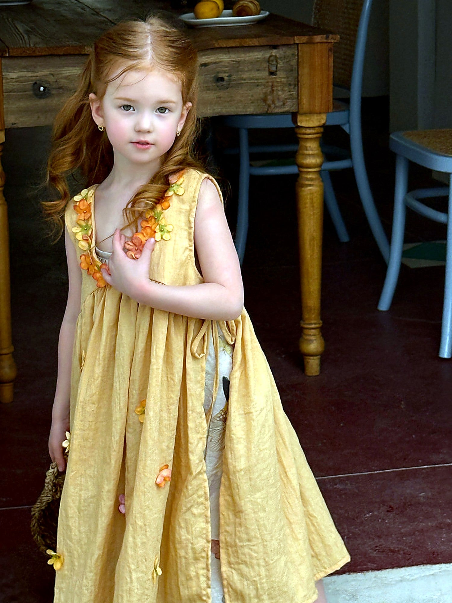 A girl moving in the Marigold Dress, the full tiered skirt swinging.