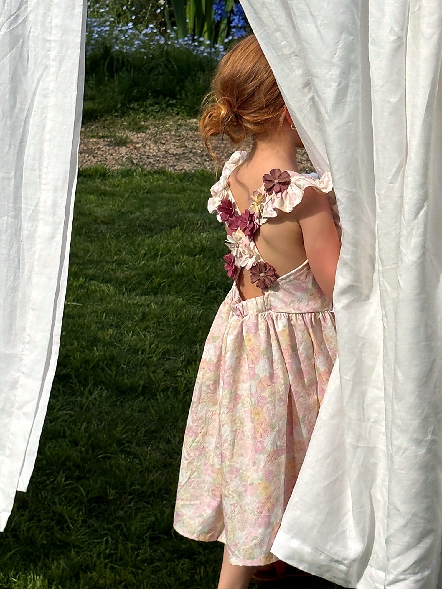 Back of the Peony Dress with soft tied straps and a small cluster of fabric flowers.