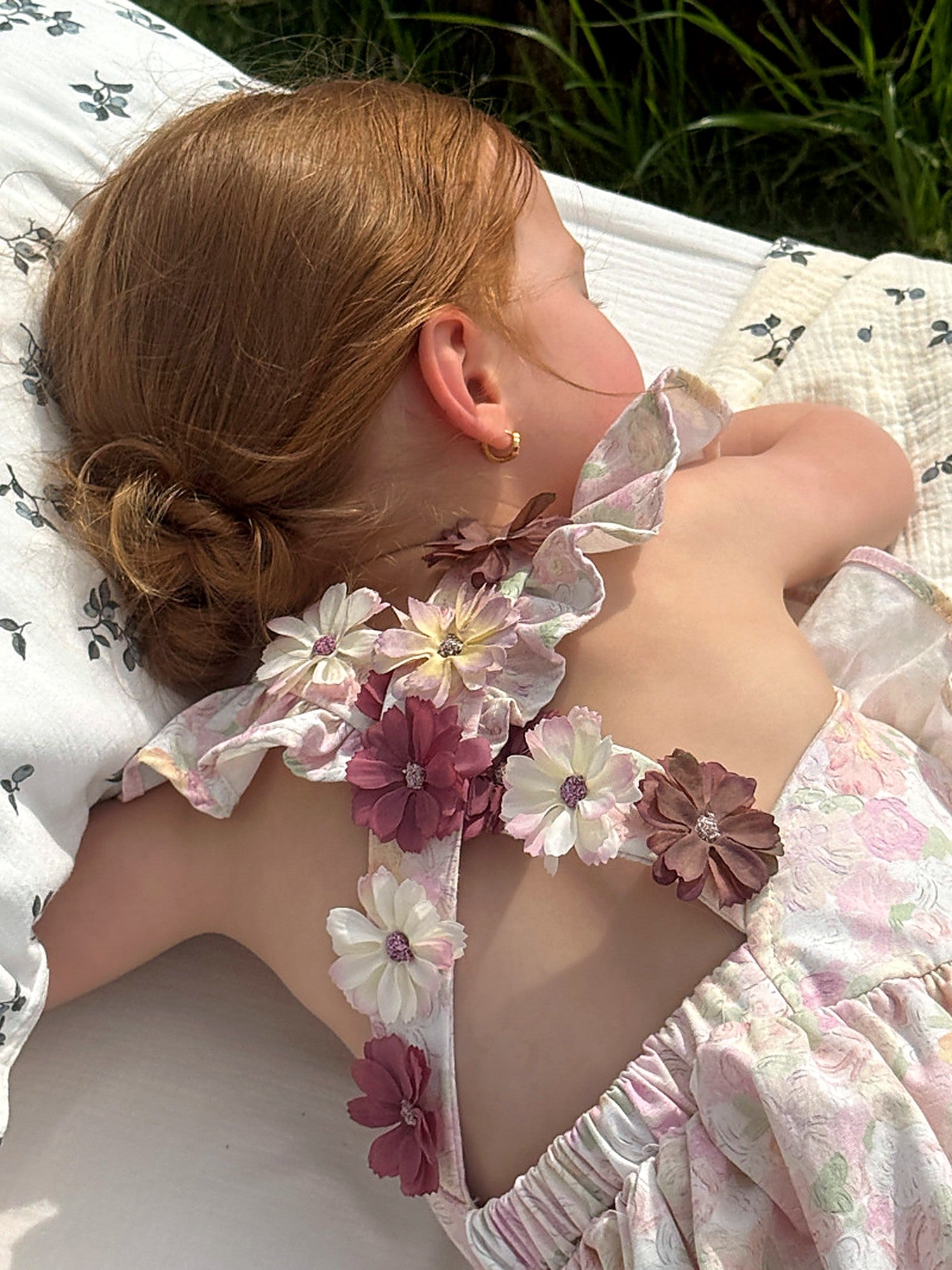 Close detail of the mauve fabric-flower corsage on the open back of the Peony Dress.