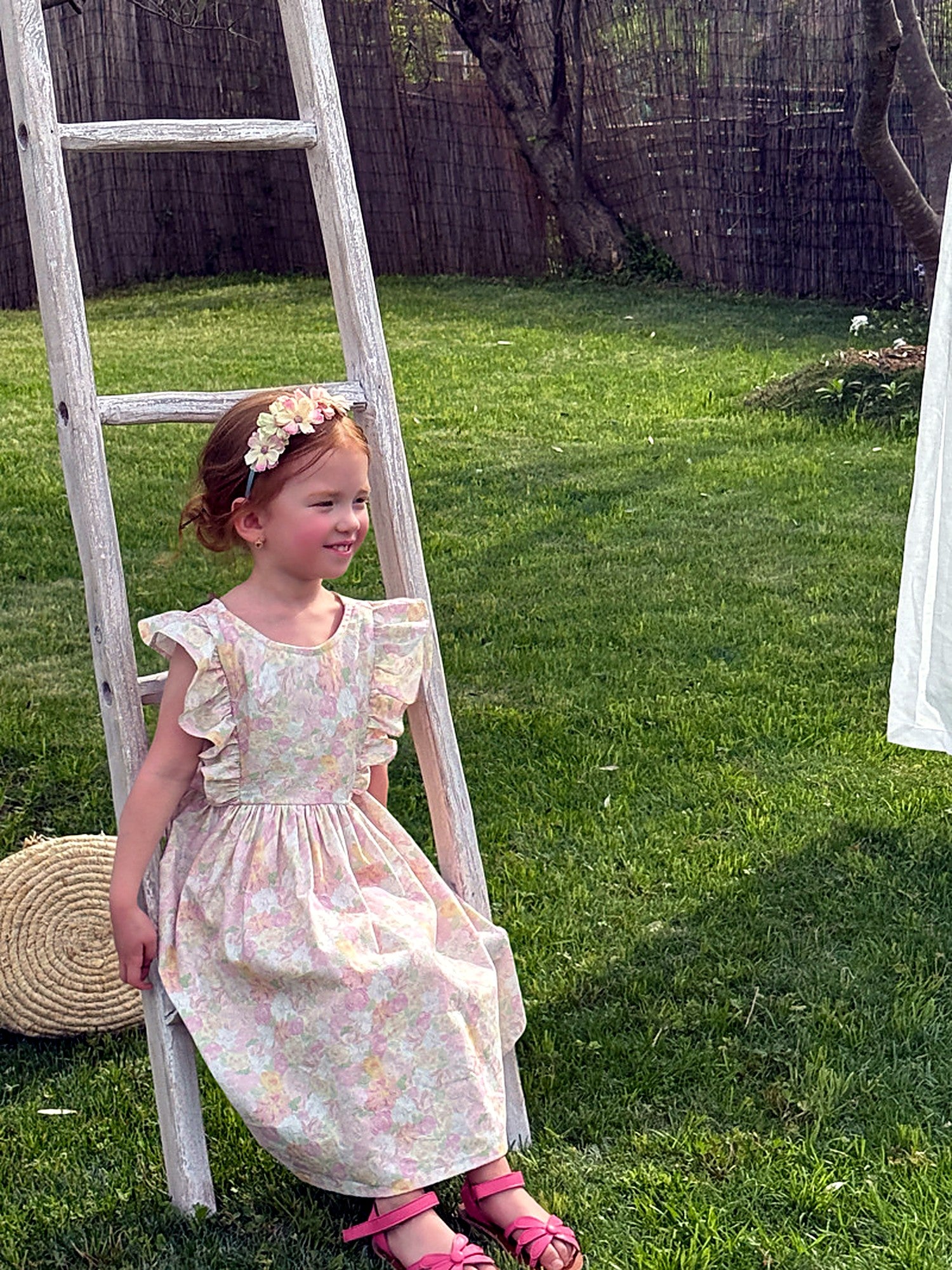 Front view of the Peony Dress — flutter sleeves and a ruffled neckline in a soft floral print.