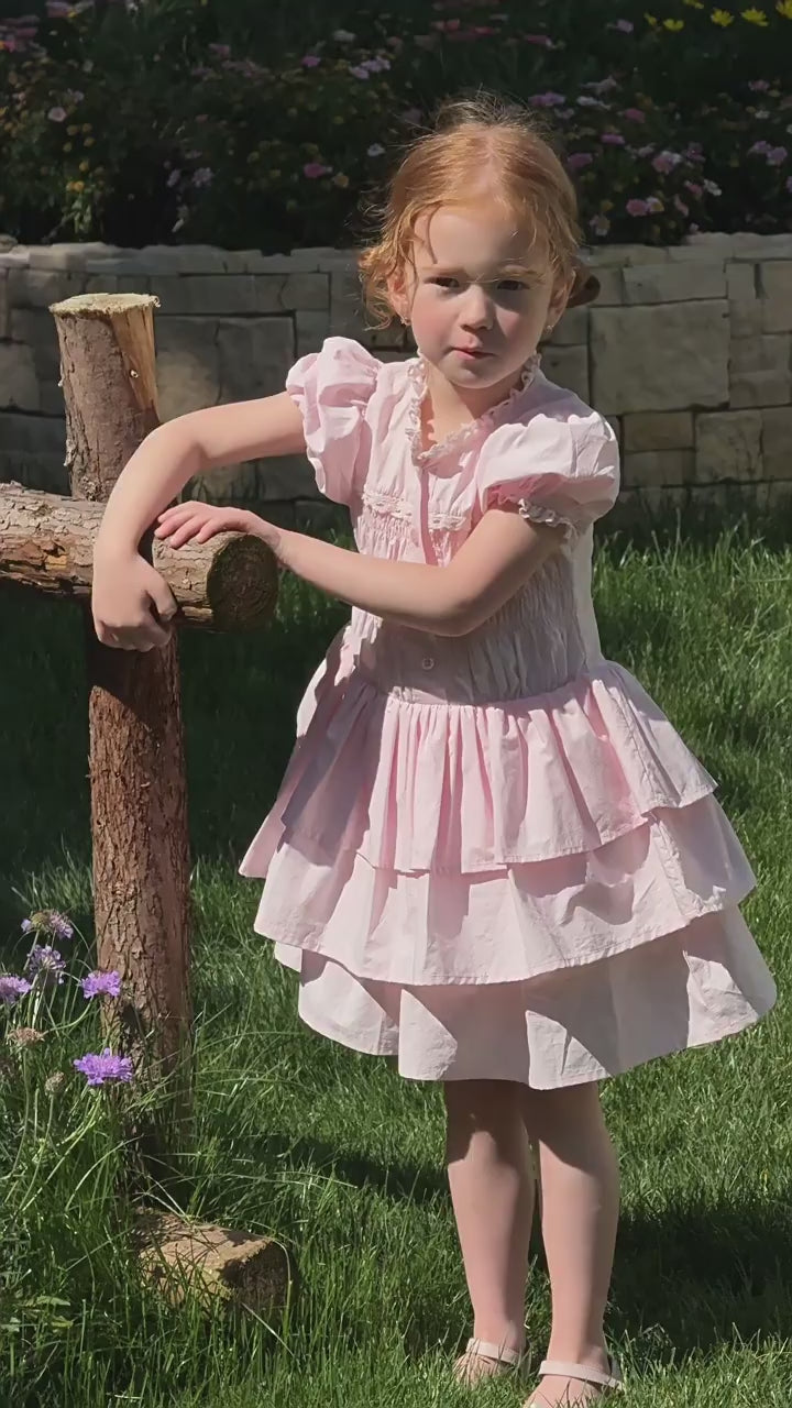 Short film of the Foxglove Dress — blush pink with puff sleeves and a smocked bodice, in the afternoon light.