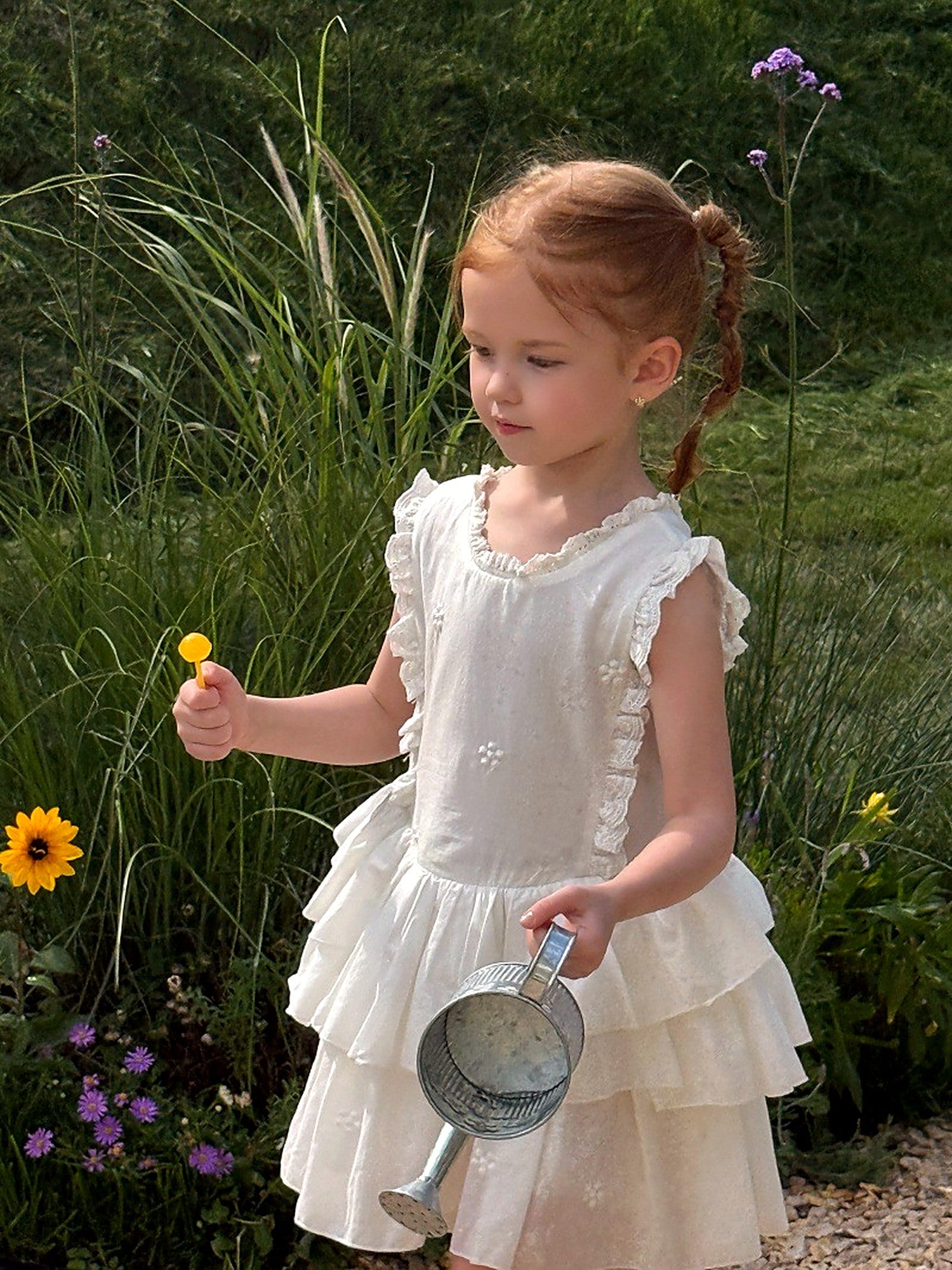 Front of the Snowdrop Dress — sleeveless, with tiers of ruffle in ivory cotton.
