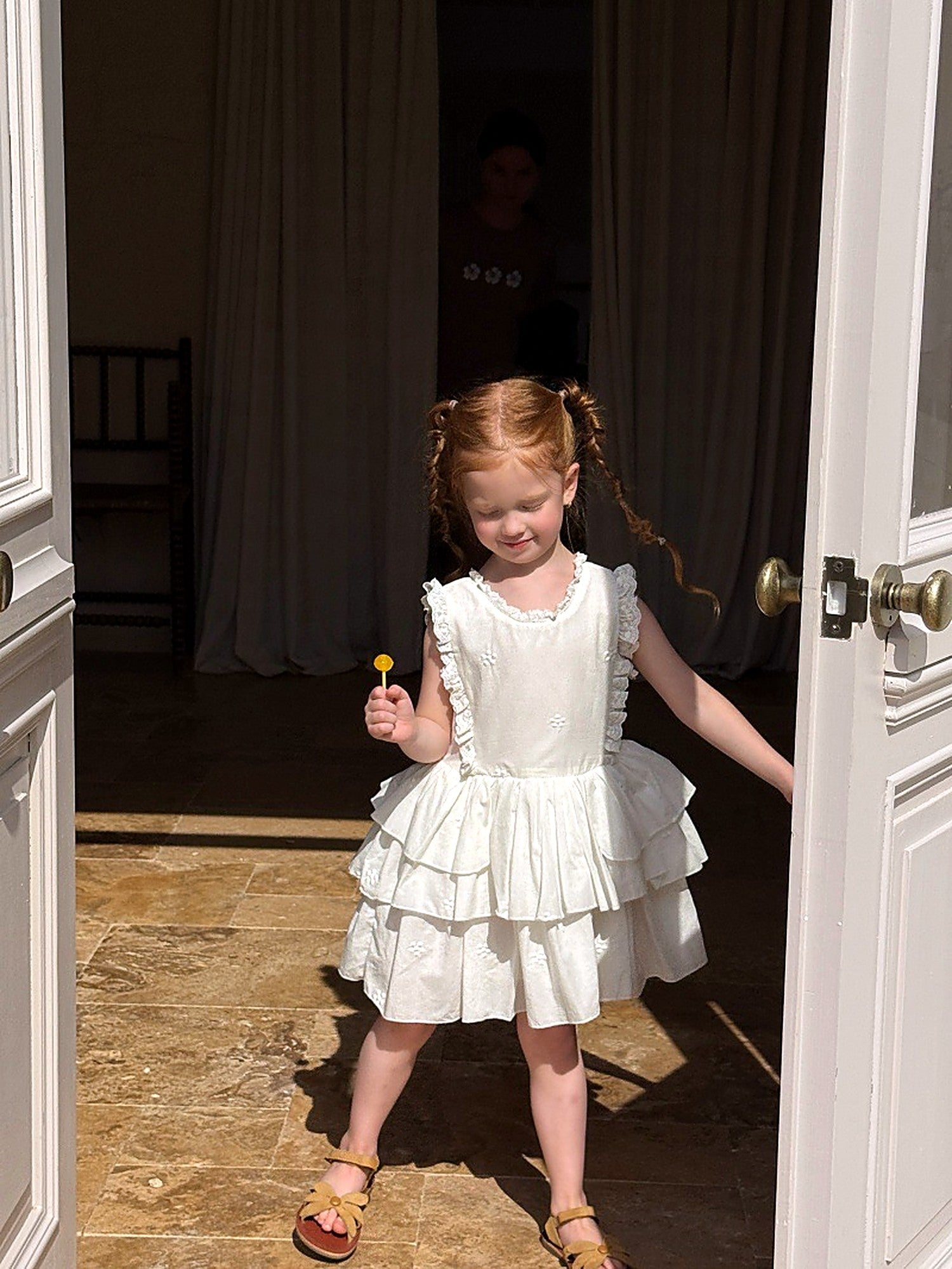 The ivory Snowdrop Dress, a flower-girl dress in tiered cotton and lace.